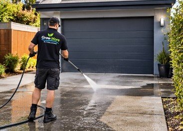 Washing a concrete driveway in front of a garage